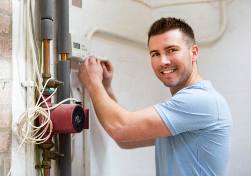 Contractor Smiling While Repairing Residential Heating in St. Louis MO