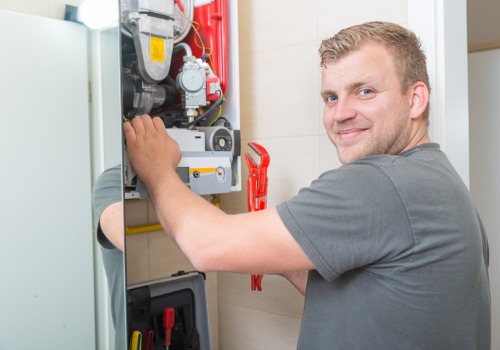 I smiling technician performing furnace service in the St. Louis MO area