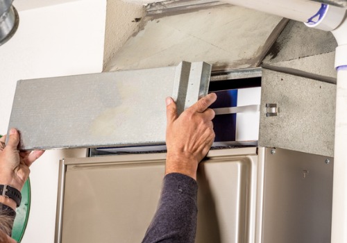 A technician removing an access panel to a furnace during Furnace Maintenance in the St. Louis MO area