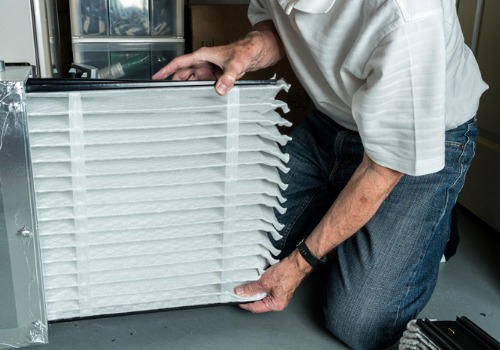 A technician replacing a filter during Furnace Maintenance in Florissant MO