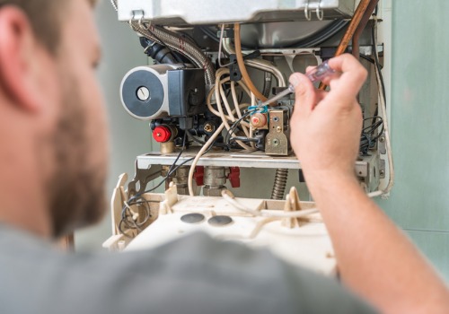 A technician checking the wiring of a furnace during HVAC Repair in the St. Louis MO area