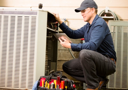 A technician working on an outside AC unit during Air Conditioning Maintenance in Kirkwood MO