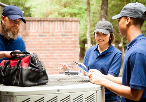 Group of professionals discussing AC repair near an AC unit in the St. Louis MO area