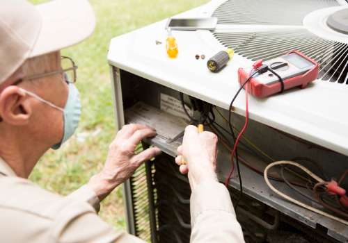 An elder repairman fixing an AC unit, part of cooling services in the St. Louis MO area