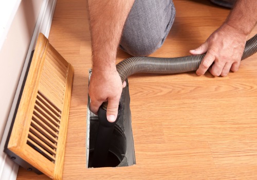 Technician putting a vacuum down a vent during Duct Cleaning in the St. Louis MO area