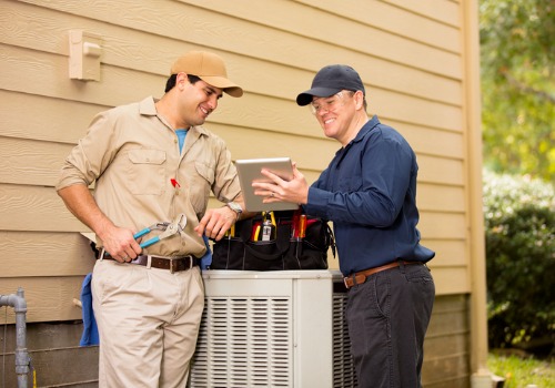 Two repairmen discussing HVAC repairs in the St. Louis MO area