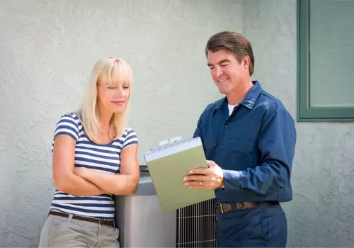 An AC tech is seen explaining an issue to the homeowner. Xcell Williams does air conditioning repair in Wentzville MO.