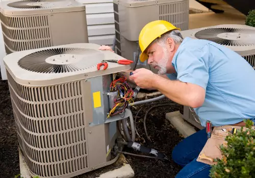 An HVAC worker is seen working on an air conditioning unit. Xcell Williams does cooling maintenance in Wentzville MO.