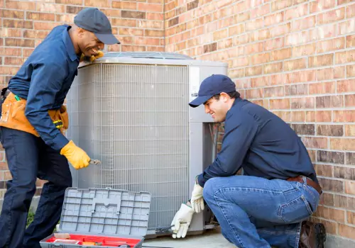 HVAC workers are seen working on an air conditioning unit. Xcell Williams does AC Service inWentzville MO.